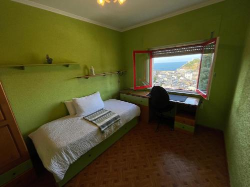 a bedroom with a bed and a desk and a window at Casa La Peña in Luarca