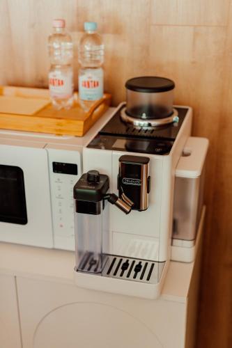 a coffee maker sitting on a counter next to a microwave at Nowoczesne Domki na Drzewie - Kołobrzeg - Sauna - PolanaGlamp in Nieżyn