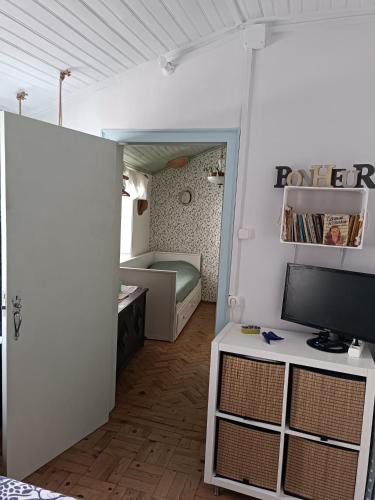 a small room with a bed and a television at Chambre familiale chez "Casa Portuguesa", accès piscine-jardin-1h15 Lisboa in Chamusca