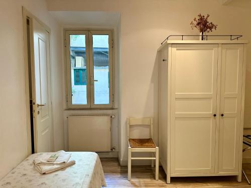 a bedroom with a bed and a cabinet and a window at B&B Santi Quattro Al Colosseo in Rome