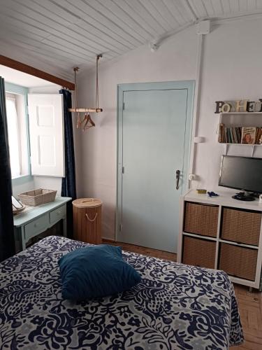 a bedroom with a bed and a desk and a door at Chambre familiale chez "Casa Portuguesa", accès piscine-jardin-1h15 Lisboa in Chamusca