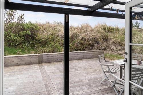 a patio with a table and chairs on a deck at 930-Thisted-Liusborg-Sti-28 in Torsted