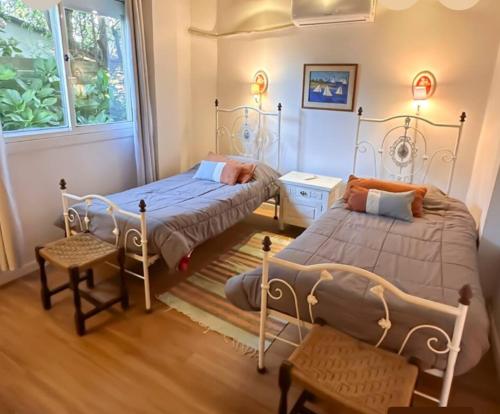 une chambre avec deux lits et une fenêtre dans l'établissement Cómoda casa vista espectacular zona Manantiales, à Balneario Buenos Aires