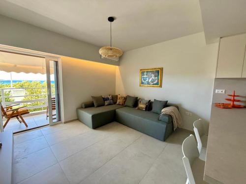 a living room with a couch and a balcony at Diana Seaside Apartment in Anavissos
