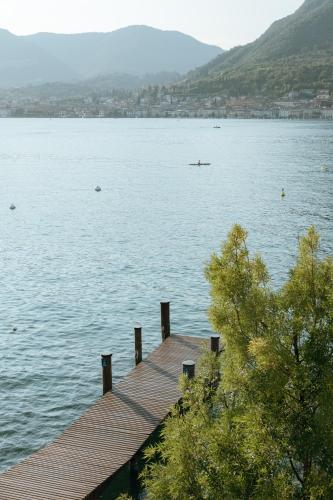 a wooden dock in the middle of a lake at Ah Porticcioli Boutique Apartments in San Felice del Benaco
