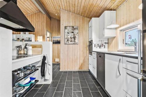 a kitchen with white appliances and wooden walls at 1030-Thisted-Lyngstien-15-A in Torsted