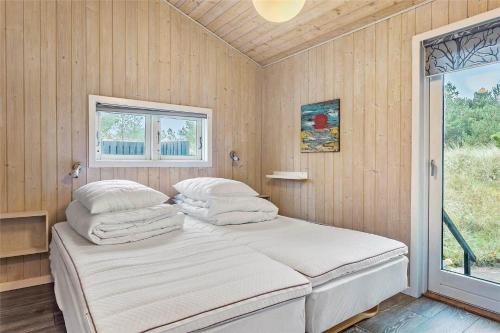 a bedroom with a bed with pillows and a window at 1030-Thisted-Lyngstien-15-A in Torsted