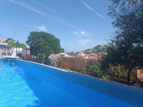 a blue swimming pool with a view of a city at Chambre familiale chez "Casa Portuguesa", accès piscine-jardin-1h15 Lisboa in Chamusca