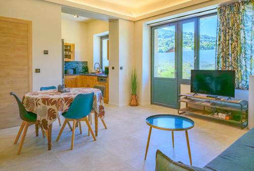 un salon avec une table, des chaises et une télévision dans l'établissement Le Joly Mont, à Saint-Gervais-les-Bains