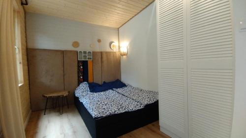 a small bedroom with a bed and a table at KOCIEWSKA DACZA - domek o podwyższonym standardzie, POMORSKIE, RZEKA, LASY, ŁĄKI in Pogódki