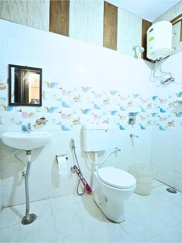 リシケーシュにあるSkyard Hostel Rishikesh Laxman Jhulaのトイレと洗面台を備えた白いバスルーム
