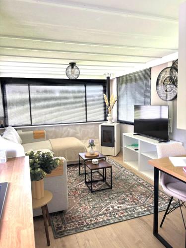 a living room with a couch and a tv at De Polderhoeve in Heerhugowaard