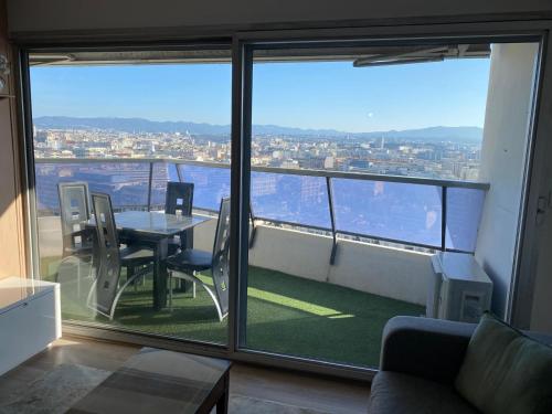 a room with a table and chairs and a large window at Vue Panoramique VÉLODROME in Marseille