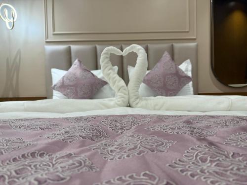 a bed with two heart shaped pillows on it at Hotel Shloka in Thane