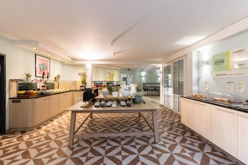 a large kitchen with a table in the middle at Garner Hotel Oberhausen in Oberhausen