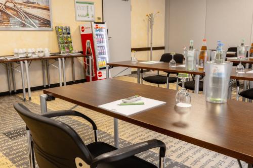a room with tables and chairs with bottles on them at Garner Hotel Oberhausen in Oberhausen