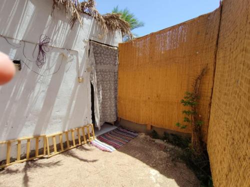 a fence with a white curtain next to a wall at Light House studio in Dahab