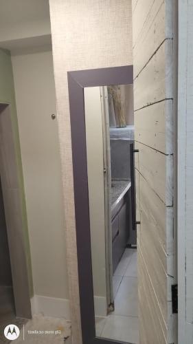 a bathroom with a mirror and a sink at Studio Romantico Privativo in Volta Redonda