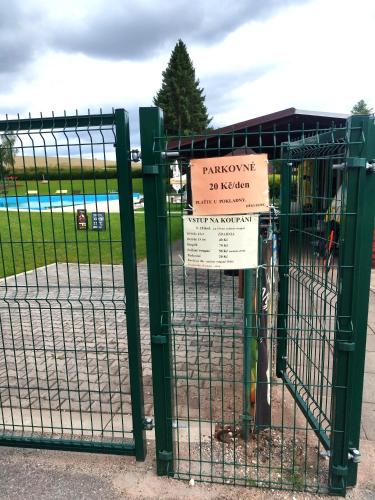 a green gate with a sign on it at Roubenka Mříčná in Mřičná