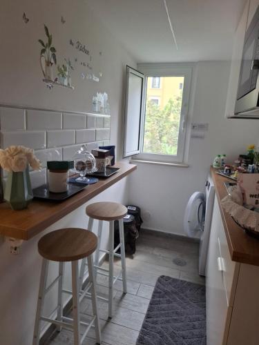 a small kitchen with two stools and a counter at The Secret Garden in Salerno