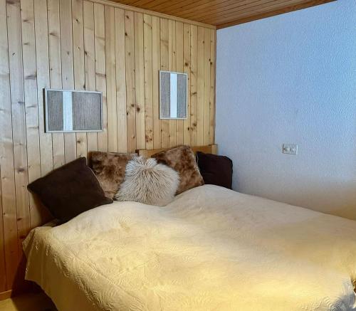 a bed in a room with wooden walls at Chalet Bliss with Spectacular Views in Chateau-d'Oex