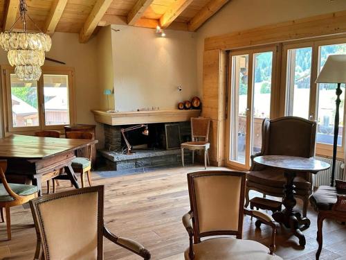 a living room with a table and chairs and a fireplace at Newly Renovated APT in Wispile Near the Park Hotel in Gstaad