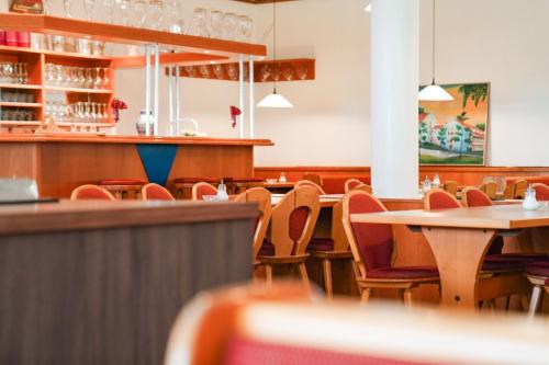 an empty restaurant with tables and chairs at Hotel Sonnenhof - Tante ALMA`s Sommerfrische in Sonnen
