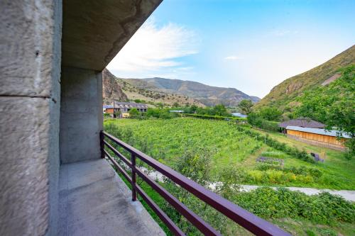 a balcony with a view of a field and mountains at Valodia's Cottage in Vardzia