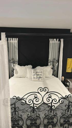 a bed with a black headboard and white pillows at Gastenverblijf de paddestoel in Urk