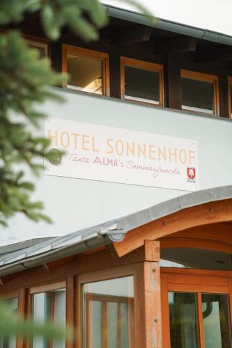 a hotel sign on the side of a building at Hotel Sonnenhof - Tante ALMA`s Sommerfrische in Sonnen