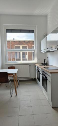 a white kitchen with a table and a window at GASTEM UG in Berlin