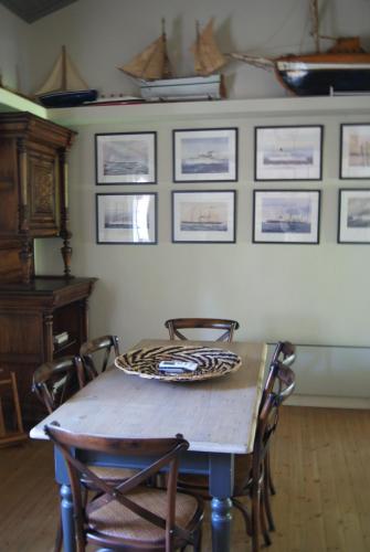 a dining room table with chairs and pictures on the wall at Villa Trypiti in Limenaria