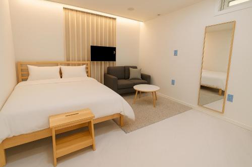 ソウルにあるJoin Stayのベッドルーム1室(ベッド1台、椅子、鏡付)