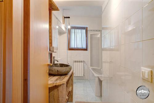 a bathroom with a stone sink and a tub at Typical apartment in Valtellina in Sondrio
