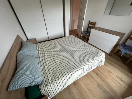 a large bed in a room with a wooden floor at Appartamento Polsa 4 in Brentonico