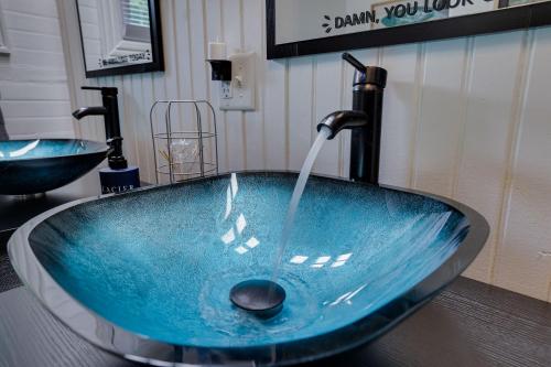 ein blaues Waschbecken mit einem Wasserhahn im Bad in der Unterkunft Heart's Desire, a Cottage With Stunning Lake Views in Effort