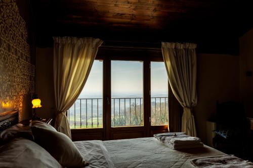 a bedroom with a bed and a large window at Alle tre Colline in Albugnano 