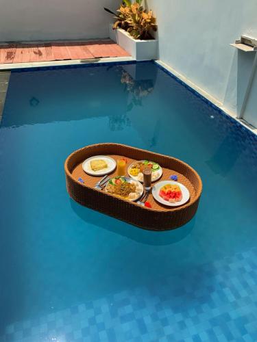 Una bandeja de comida encima de una piscina. en Avana Villa Harau, en Andalas