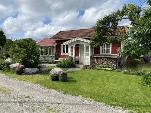 a red house with a yard with potted plants at Cozy guest house in the countryside in Håltebyn