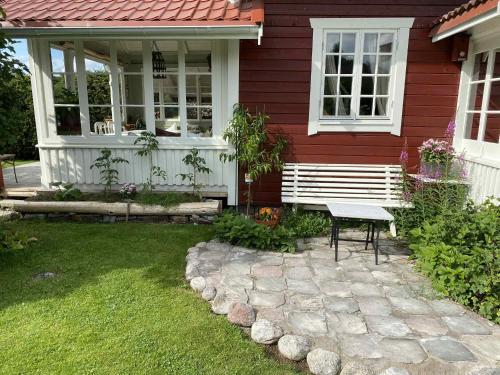 a house with a bench in the front yard at Cozy guest house in the countryside in Håltebyn