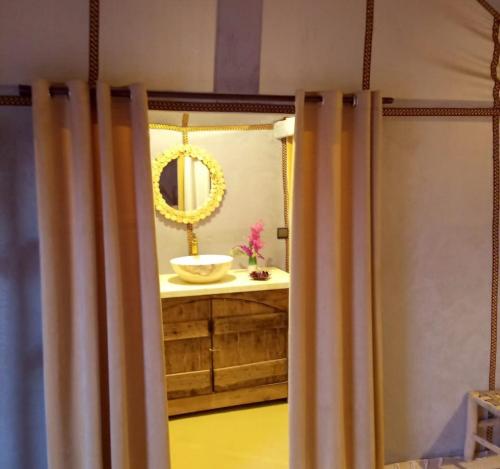a bathroom with a sink and a mirror at lion Desert luxury Camp in Merzouga