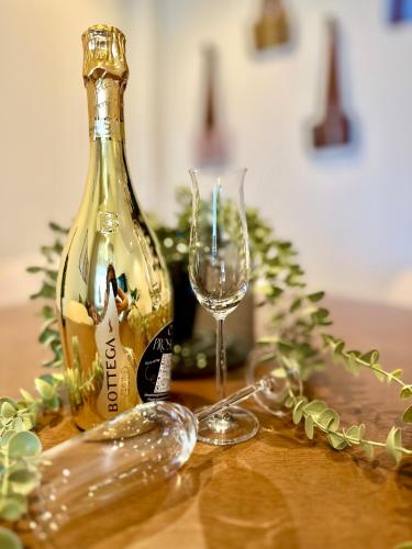 a bottle of wine and a glass on a table at Das Alpenzeit Appartement mit Just Private Terrasse in Bad Aussee