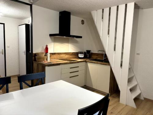 a kitchen with a table and a staircase in a room at Campanules 2 - Abondance in Abondance