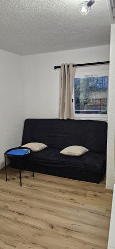 a black bed in a room with a window at Campanules 2 - Abondance in Abondance