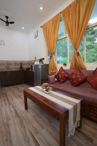 sala de estar con sofá grande y ventanas en Athira By The Lake - Nakuchiatal, en Bhimtal