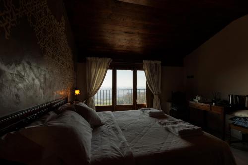 a bedroom with two beds and a large window at Alle tre Colline in Albugnano 