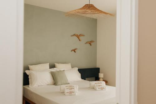 1 dormitorio con 1 cama con 2 pájaros volando sobre ella en Bella M'briana, en Polignano a Mare