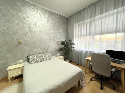 a bedroom with a bed and a desk and a computer at New apartment with sauna near Tamula lake in Võru