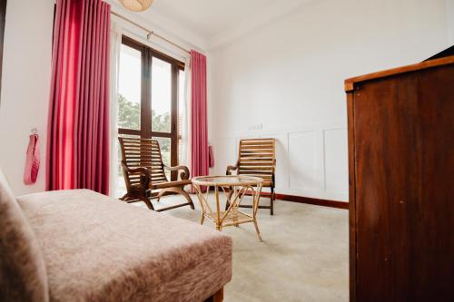 a bedroom with a bed and a table and chairs at O'Neill's Cottage in Dikkapitiya