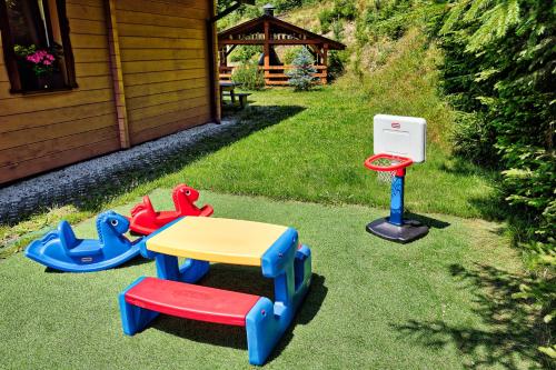 a table and three play equipment in a yard at Solna Chata-dom na wyłączność Grota solna, balia, sauna, basen in Rajcza